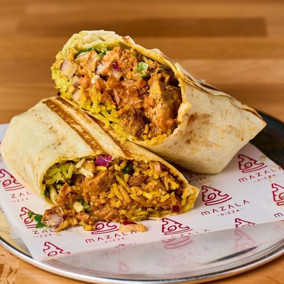 Two halves of a chicken and rice wrap, filled with sauce and vegetables, on Mazala branded paper.